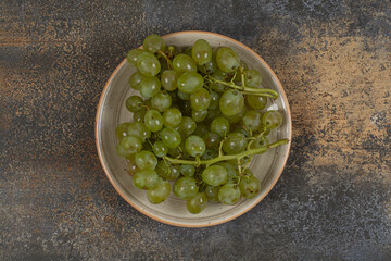 Fresh green grapes on ceramic plate