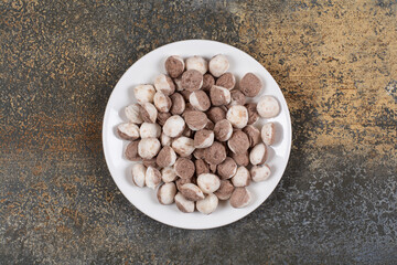Bunch of brown candies on white plate