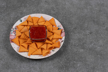 Triangle shaped crackers on plate with ketchup