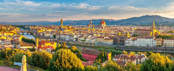 Panoramic view of Arno river, with Ponte Vecchio, Palazzo Vecchio and Cathedral of Santa Maria del Fiore at sunrise in Florence, Italy. Architecture and landmark of Florence. - obrazy, fototapety, plakaty
