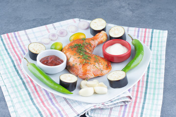 Marinated chicken on plate with sliced vegetables