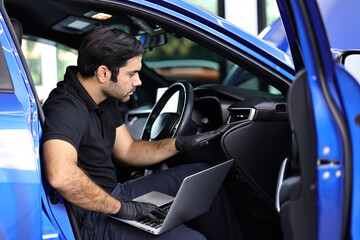 Fototapeta na wymiar The car's electronic programming uses the laptop to link and checks the data in the engine by monitoring the digitization display to keep and tune the best performance of the engine in the car repair.