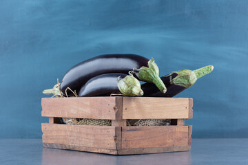 Ripe fresh eggplants in wooden box