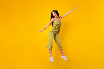 Fototapeta na wymiar Full body photo of pretty cheerful thai person have good mood jumping isolated on yellow color background