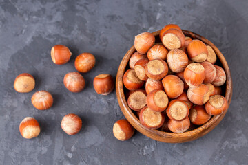Hazelnut in wooden bowl on black background. Organic hazelnut.