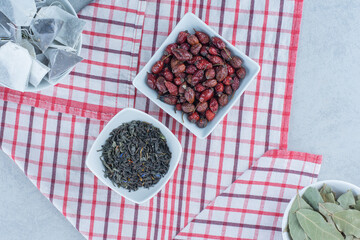Tea bags , leaves, rosehip and dry tea leaves , on the marble background