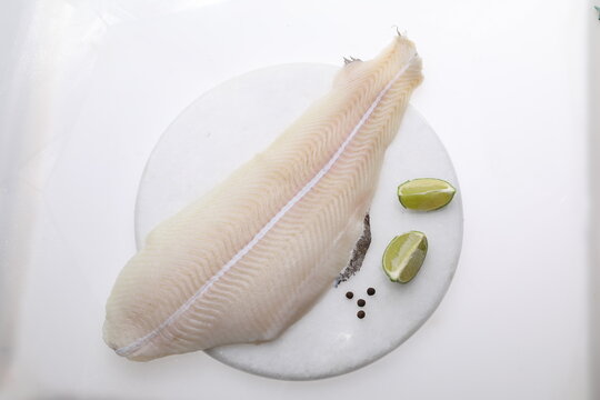 Lemon sole fillet on a white background, a packshot photo for fish shop, top view.