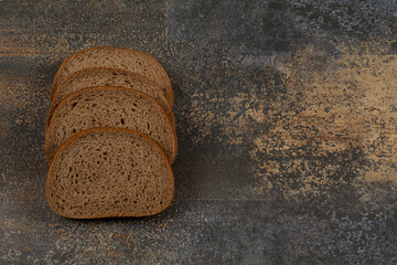 Sliced black rye bread on marble background