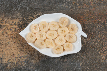 Sliced peeled bananas on white plate