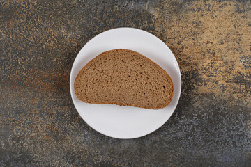 One black bread slice on white plate
