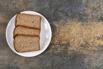 Three slices of black bread on white plate
