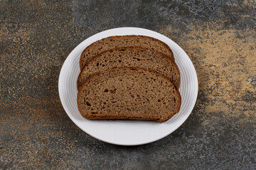 Rye black bread slices on white plate