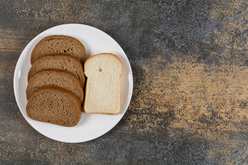 Black and white bread slices on white plate