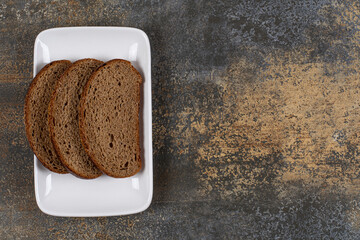 Sliced rye bread on white square plate