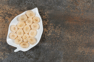 Sliced peeled bananas on white plate