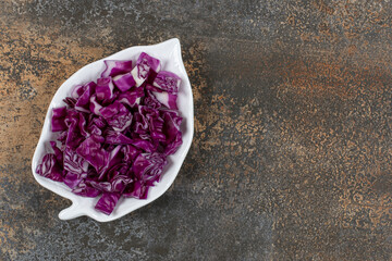Leaf shaped red cabbage plate, on the marble background
