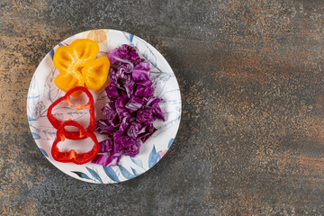 Sweet peppers and finely chopped red cabbage, on the marble background