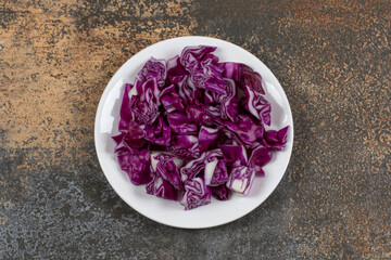 Obraz na płótnie Canvas A plate of chopped red cabbage, on the marble background