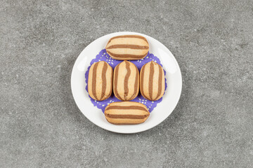 Delicious chocolate striped biscuits on white plate