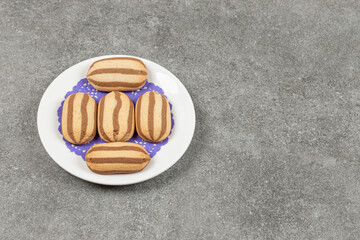 Delicious chocolate striped biscuits on white plate