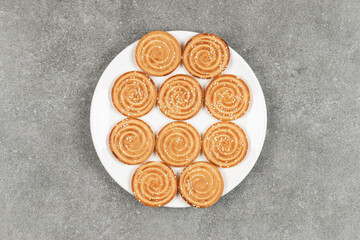 Plate of delicious round biscuits on marble background
