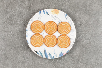 Round biscuits with sesame seeds on colorful plate