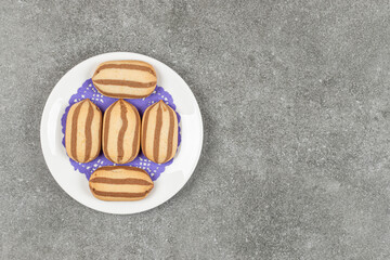 Delicious chocolate striped biscuits on white plate