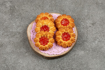 Homemade cookies with jelly on wood piece