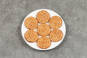 Plate of delicious round biscuits on marble background