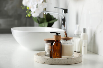 Tray with dispenser bottle and cosmetic products on white table in bathroom