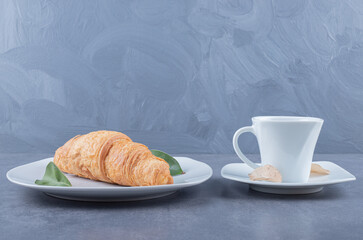 Cup of Cappuccino and croissant for breakfast on grey background