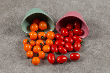 Two bowls of overturned tomatoes, on the marble background