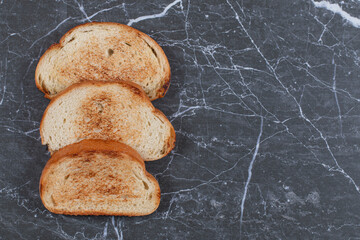 Arranged bread slices in a row on the marble background