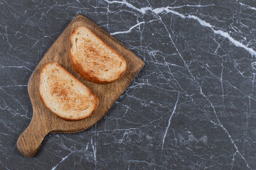 Two piece of fried bread on board , on the marble background