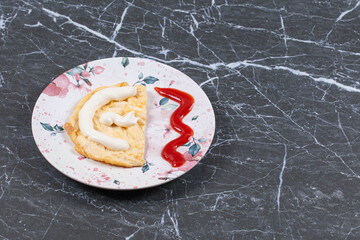 Mayonnaise on omelette next to ketchup , on the marble background