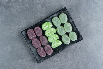 Fototapeta na wymiar Fruit jelly sweet colorful candies on a dark plate
