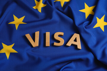 Word Visa made of wooden letters on European Union flag, above view