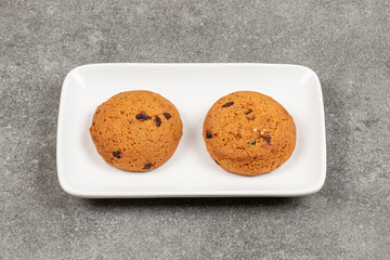 Two chocolate cookies on white plate