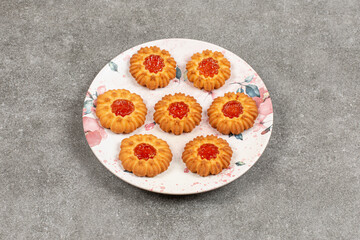Bunch of biscuits with jelly on colorful plate