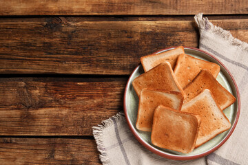 Slices of tasty toasted bread on wooden table, top view. Space for text
