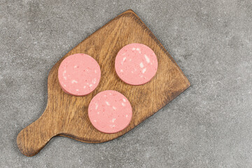 Sliced salami on wooden cutting board