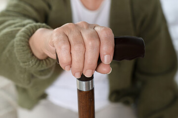 Fototapeta premium Elderly woman with walking cane indoors, closeup. Home care service