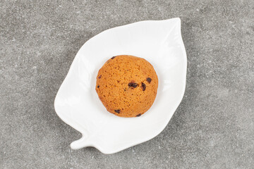 Single chocolate cookie on white plate