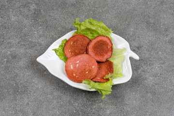 Grilled salami and lettuce on white plate