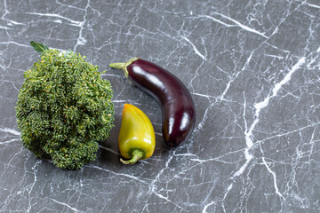Broccoli, pepper and eggplant on marble background