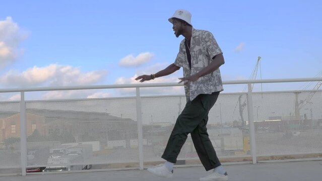 Black guy break-dancing on the rooftop. Freestyle dance routine.
