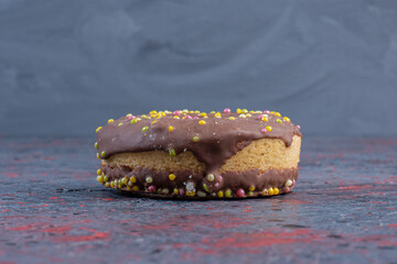 Close up photo of fresh chocolate donut on colorful background