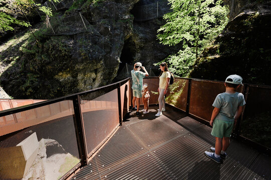 Mother with children stand in metal stairs in Liechtensteinklamm or Liechtenstein Gorge, Austria.