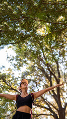Caucasian happy woman breathing deeply on the mountain with open arms