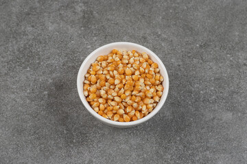 Pile of raw corn kernels in white bowl